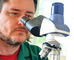 Stephen Klusza with a microscope