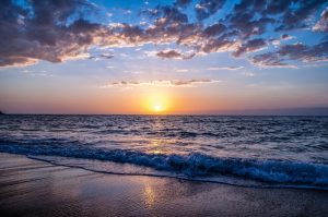 Photo of sun setting over the ocean.