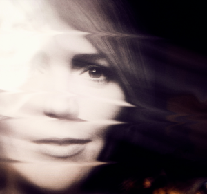 A blurred image of a human face is shown against a dark background.